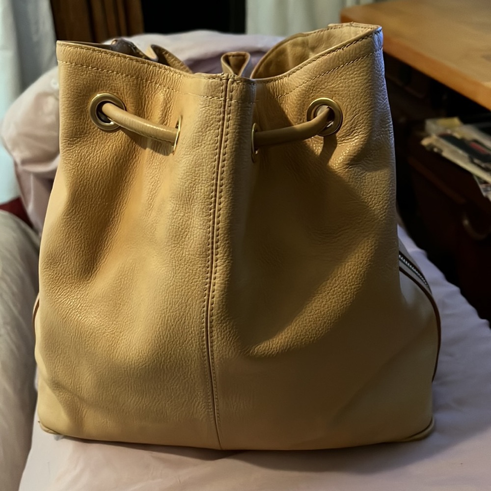 BRAHMIN Bucket Bag: beige with drawstring closure and 2 side zippers.